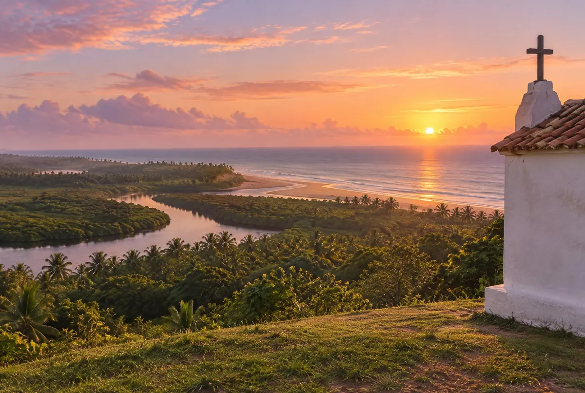 Amanhecer no mirante: a quina branca da igreja, a escarpa verde e o rio cortando o mangue até o mar.